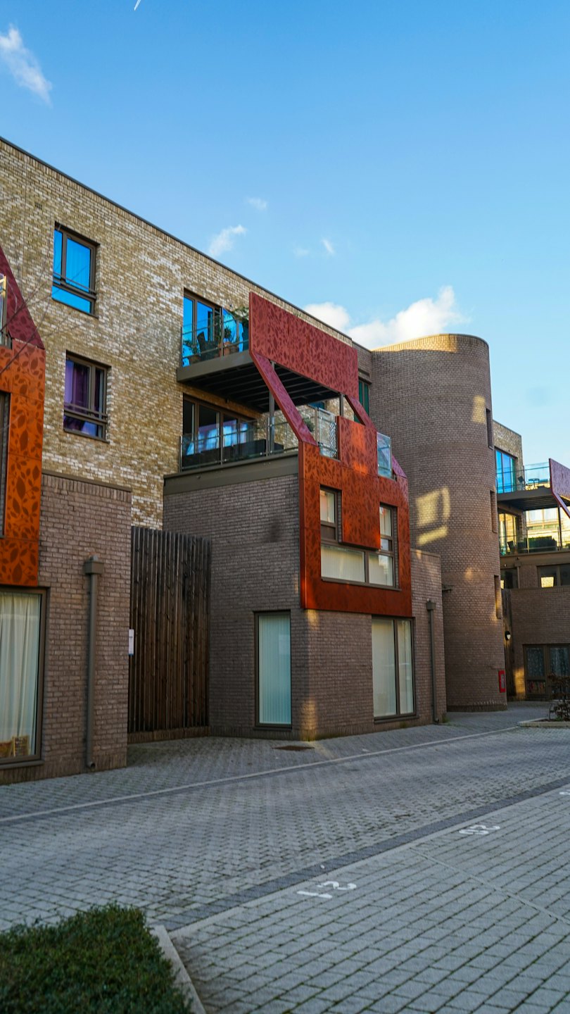 Modern apartment buildings with brick facades and large glass windows.